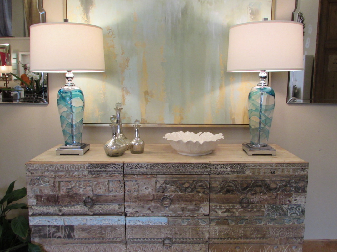 Carved chest of drawers $1,375; decorative glass decanters, $45-$75; abstract painting, $1,145; Andreas glass table lamps, $339 each; white stoneware leaf bowl, $69 – all found at Merridian Home Furnishings Carved chest of drawers $1,375; decorative glass decanters, $45-$75; abstract painting, $1,145; Andreas glass table lamps, $339 each; white stoneware leaf bowl, $69 – all found at Merridian Home Furnishings