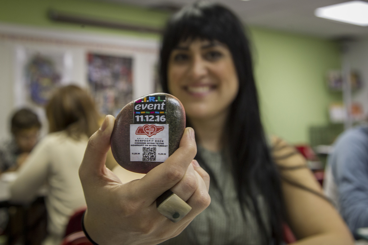 Jaclyn shows off the QR code on a Grit.Grind.Give. rock. Jaclyn shows off the QR code on a Grit.Grind.Give. rock.
