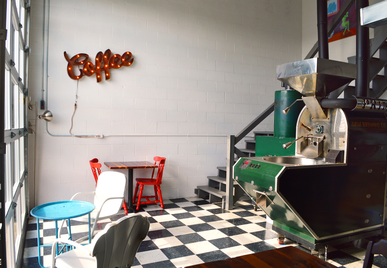 The back room at Bean houses additional seating alongside the coffee roaster. A glass garage door keeps the room filled with natural light. The back room at Bean houses additional seating alongside the coffee roaster. A glass garage door keeps the room filled with natural light.