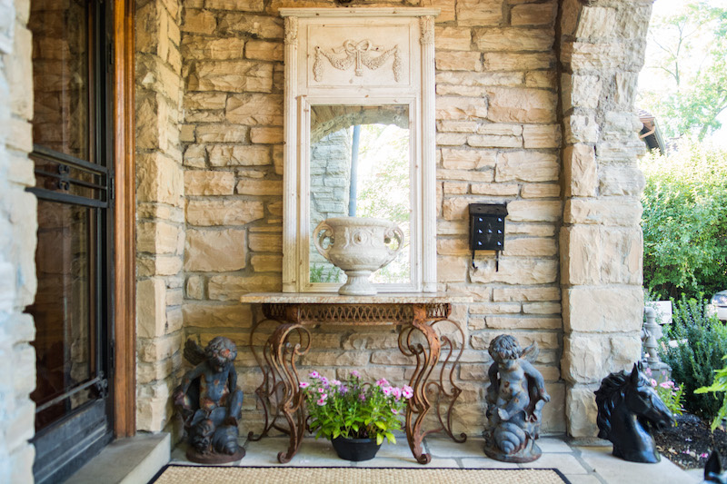 Side wall of porch decorated with a mirror and end table Take a look inside the Bellarmine Show House 2016