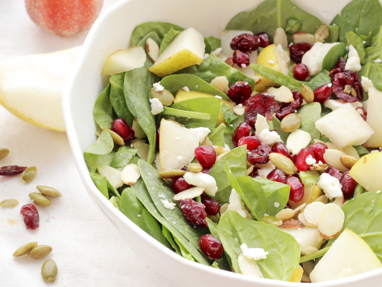 Tart pomegranate arils and dried cranberries, nutty almond slivers and pumpkin seeds, sweet chunks of Bartlett pears and salty feta cheese combine over earthy spinach leaves for a beautiful fall salad. Tart pomegranate arils and dried cranberries, nutty almond slivers and pumpkin seeds, sweet chunks of Bartlett pears and salty feta cheese combine over earthy spinach leaves for a beautiful fall salad.