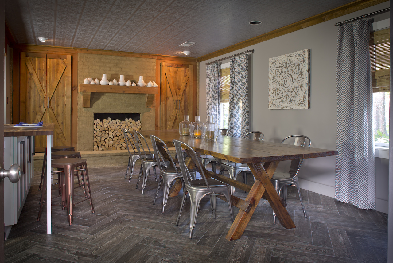The reclaimed wood dining table can seat 18 guests. A non-working fireplace at one end of the dining area is artfully stacked with birch logs. Image | Justin Fox Burks The reclaimed wood dining table can seat 18 guests. A non-working fireplace at one end of the dining area is artfully stacked with birch logs. Image | Justin Fox Burks