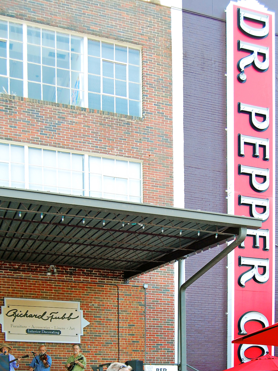Musicians play live music beside the iconic Dr. Pepper Co. building sign. Musicians play live music beside the iconic Dr. Pepper Co. building sign.