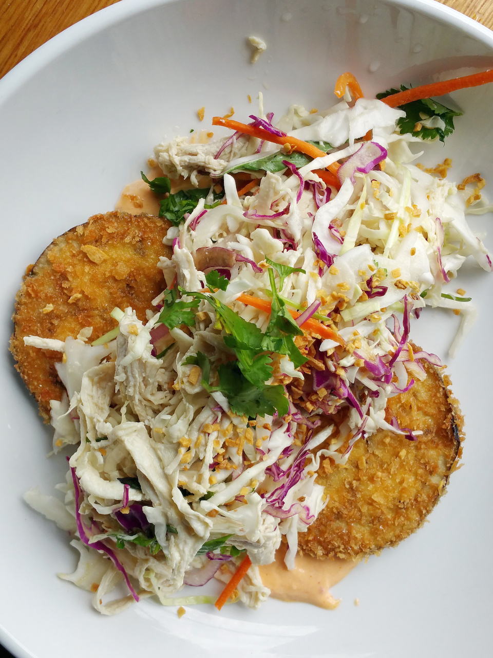 A refreshing chicken salad appetizer on crispy fried eggplant slices and topped with red cabbage, carrots, peanuts and cilantro A refreshing chicken salad appetizer on crispy fried eggplant slices and topped with red cabbage, carrots, peanuts and cilantro