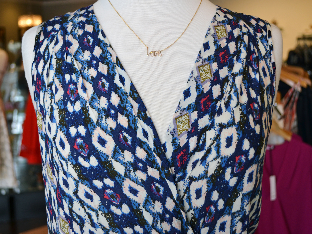 Closeup on Love necklace and print of jumpsuit june what to wear