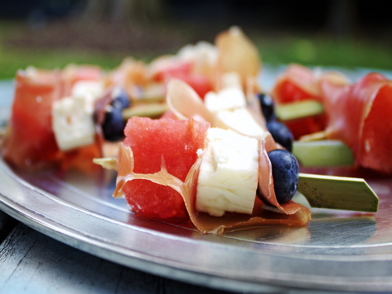 We love these tiny appetizer sized skewers. Thinly sliced proscuitto, feta, blueberry and watermelon skewers.