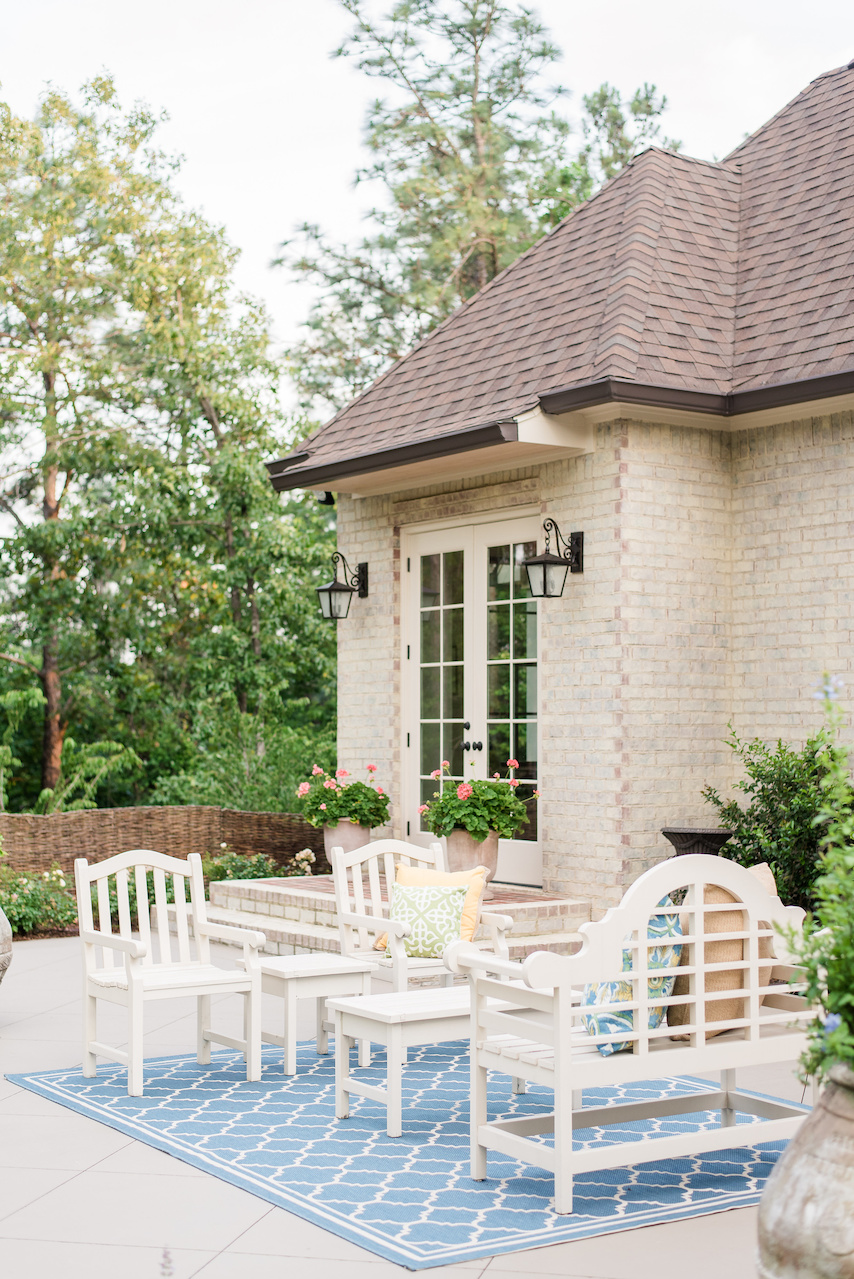 "For the patio, we chose white, simple furniture that didn’t detract from the garden and a pop of color with the rug and pillows," says Clarke. "For the patio, we chose white, simple furniture that didn’t detract from the garden and a pop of color with the rug and pillows," says Clarke.