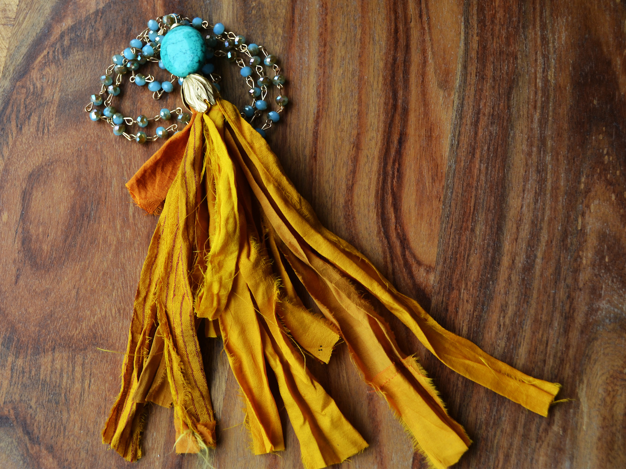 Closeup of gold silk tassel necklace with turquoise beads june what to wear