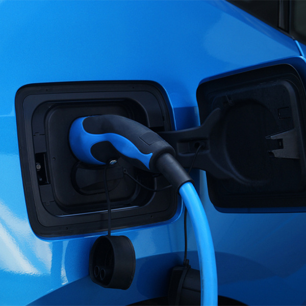 A blue passenger EV charges from a blue charging gun