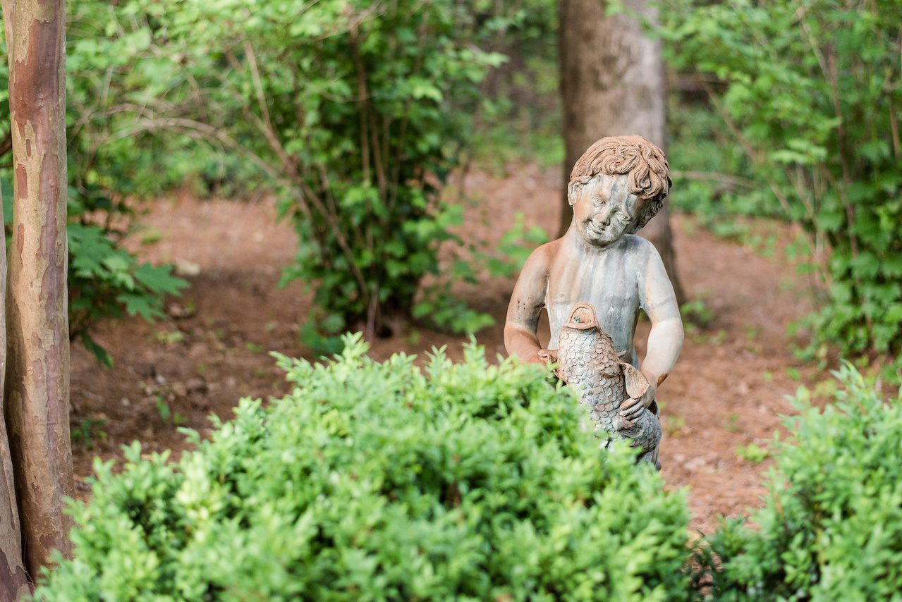 A cherub peeks into the mossy garden. A cherub peeks into the mossy garden.