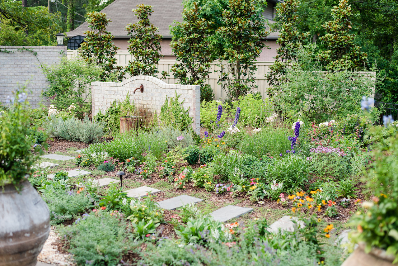 The landscape in the back of the home is more colorful and wild with walkways among the flowers and herbs. The landscape in the back of the home is more colorful and wild with walkways among the flowers and herbs.