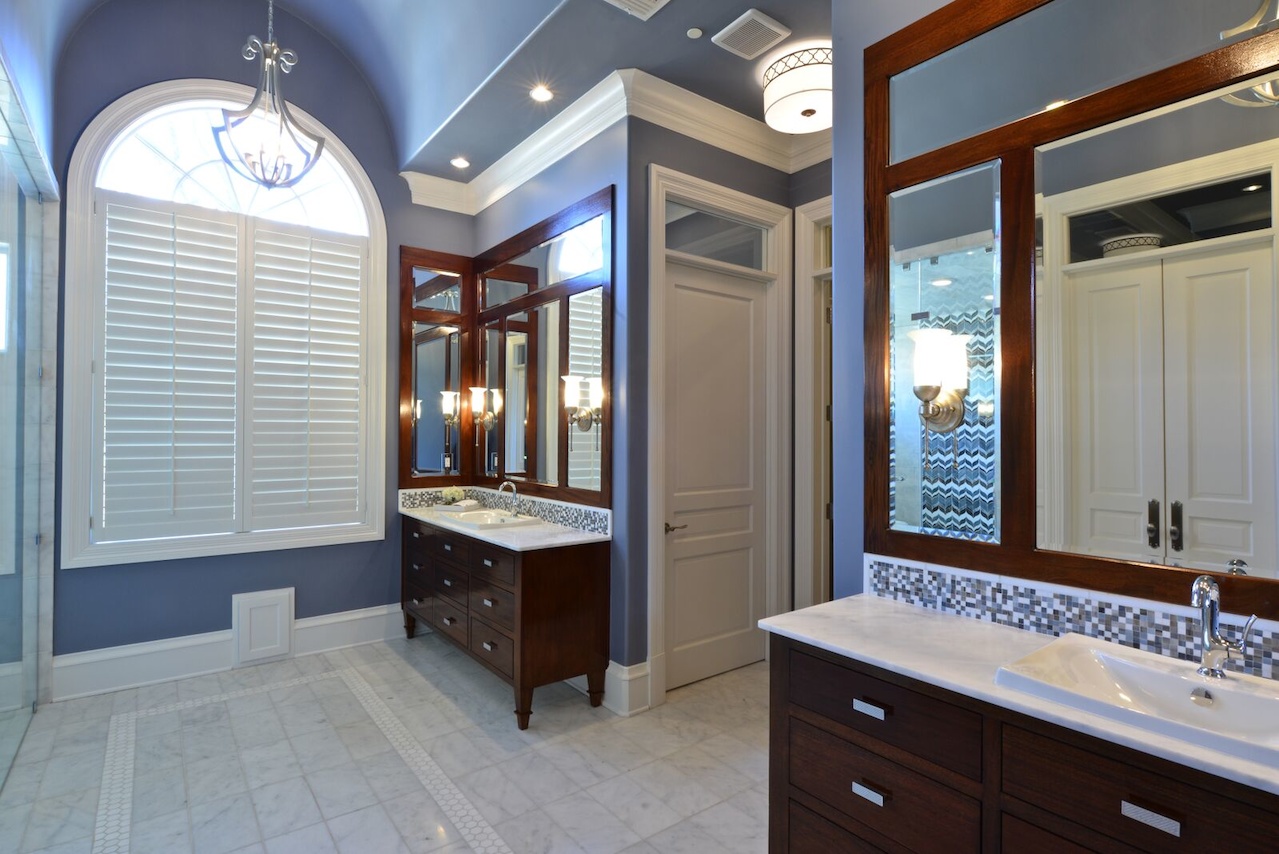 A dark wood stain on the vanities contributes to the rich look, with a mosaic tile backsplash as an added detail. A dark wood stain on the vanities contributes to the rich look, with a mosaic tile backsplash as an added detail.