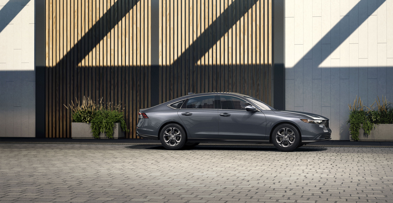 A grey 2023 Honda Accord parked in front of a slat wall.