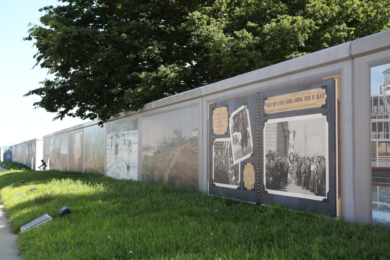 The long flood wall with hand-painted murals welcomes visitors to town and illustrates the rich history of Paducah. The long flood wall with hand-painted murals welcomes visitors to town and illustrates the rich history of Paducah.