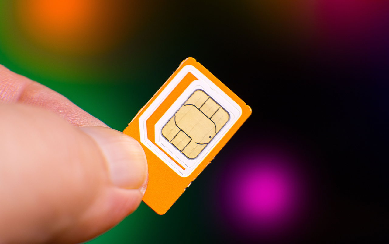 Eine Person hält eine Nano-SIM-Karte in den Fingern.