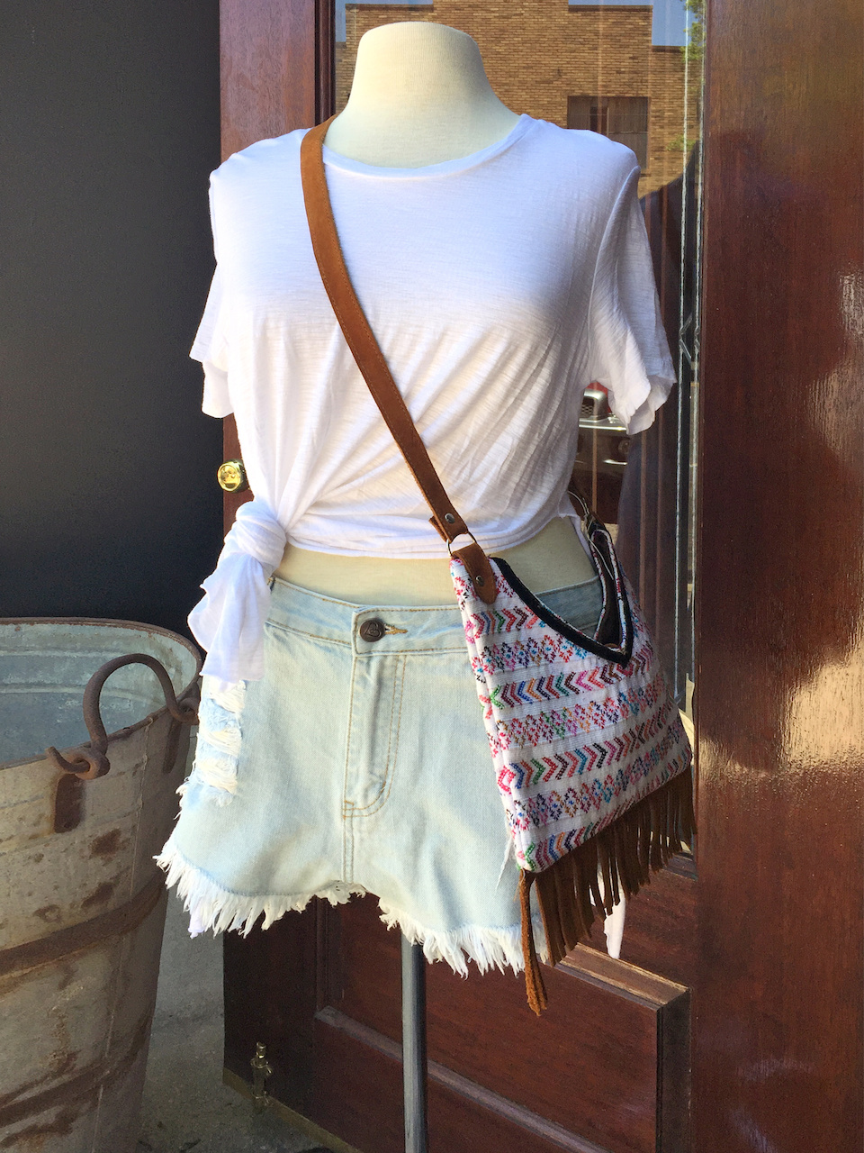 From Ambiance: white front-tie tee, $36.75; denim shorts, $39; handmade Guatemalan purse with fringe, $65 From Ambiance: white front-tie tee, $36.75; denim shorts, $39; handmade Guatemalan purse with fringe, $65