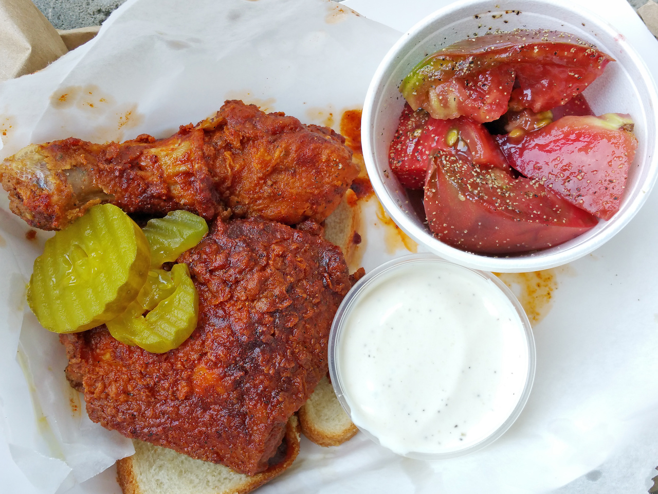 Dark meat hot chicken plate with a side of heirloom tomatoes from Eugene's Hot Chicken Dark meat hot chicken plate with a side of heirloom tomatoes from Eugene's Hot Chicken
