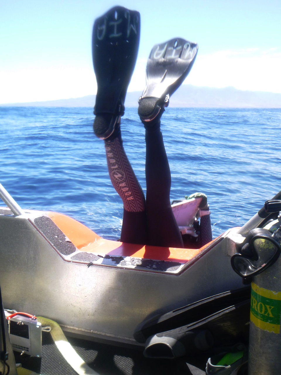 Quantitative Underwater Ecological Surveying Techniques (QUEST) Intern Mia Lamirand executes a textbook backroll into the waters off Lana'i to begin her fish survey. The Pacific Islands Fisheries Science Center offers graduates of the UH-Hilo QUEST Program the opportunity to join these expeditions. Interns complete up to 4 dives each day, collecting data alongside senior scientists, and honing their marine science survey skills. <br><i>Photo: NOAA Fisheries/Raymond Boland.</i>