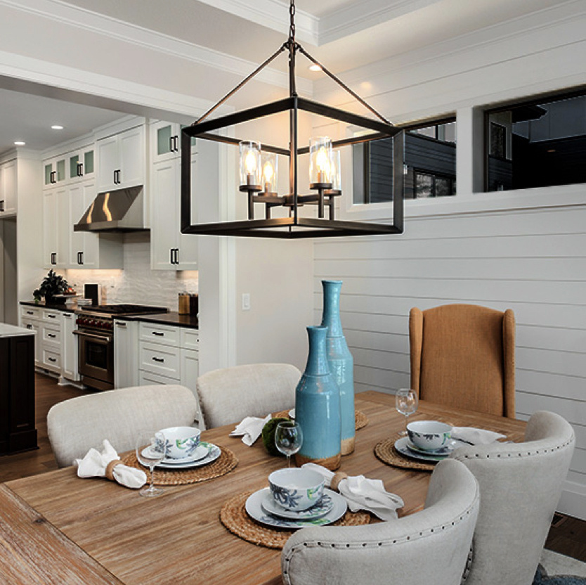 kitchen table with white shiplap walls and metal chandelier