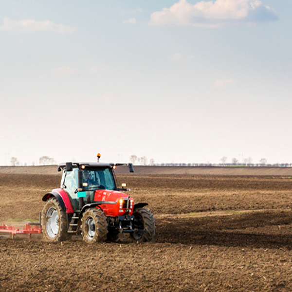 red tractor plowing field