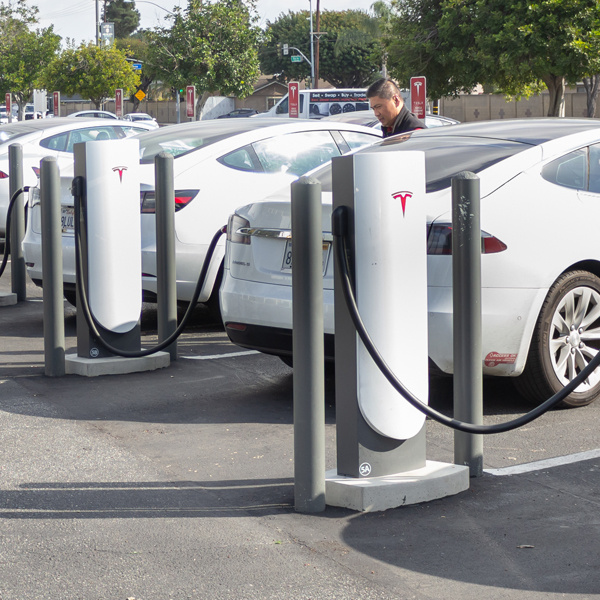 White automobiles at charging stations