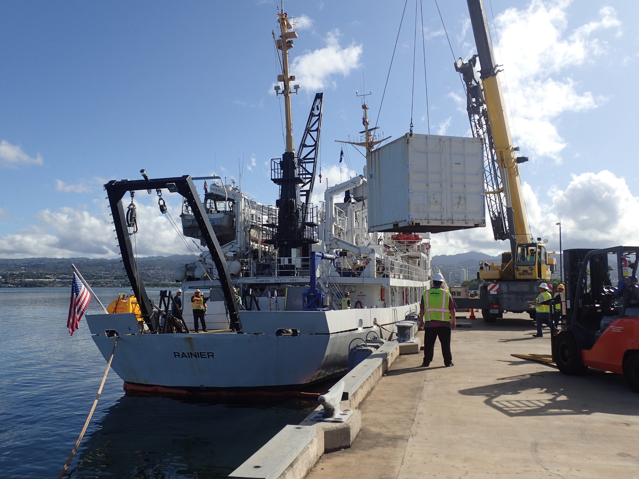 Loading day! Safety officals stand by as a large crane moves our mobile lab from the pier onto the <i>Rainier</i>. The scientists will use this for (air conditioned!) lab space to store and prep gear, as well as process samples from the field. <i>Photo: NOAA Fisheries/James Morioka. </i>