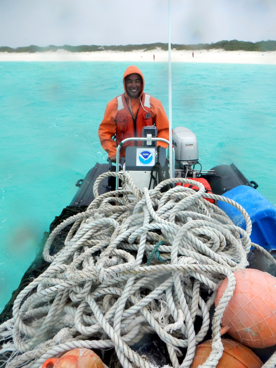 NOAA Coral Reef Ecosystem Program Marine Debris team lead, James Marioka, navigates one of the inflatable boats full of derelict fishing nets away from Kure Atoll. The abandoned gear will be loaded onto NOAA Ship Hi'ialakai for transport back to Honolulu along with the rest of the debris collected during the mission. Photo: NOAA Fisheries