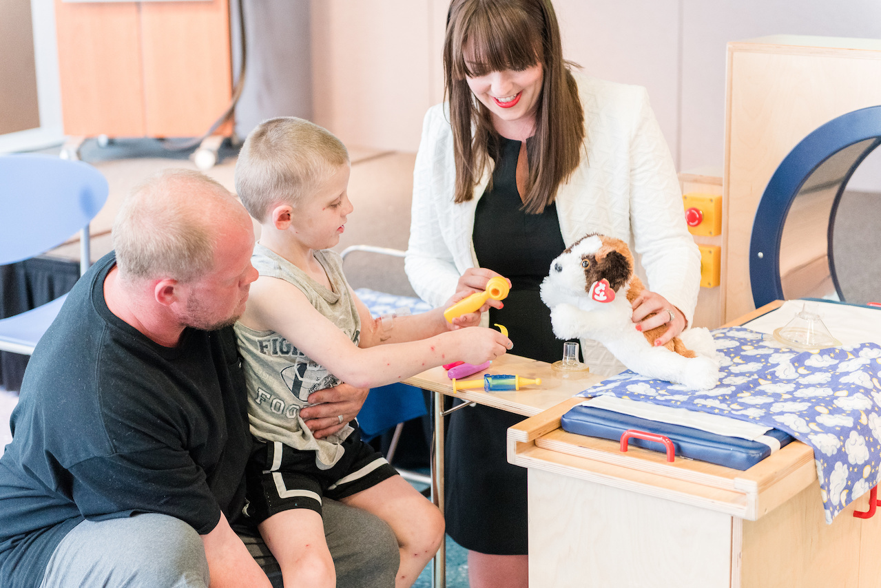 Chandler helps a pint-sized patient doctor up a stuffed animal. Chandler helps a pint-sized patient doctor up a stuffed animal.