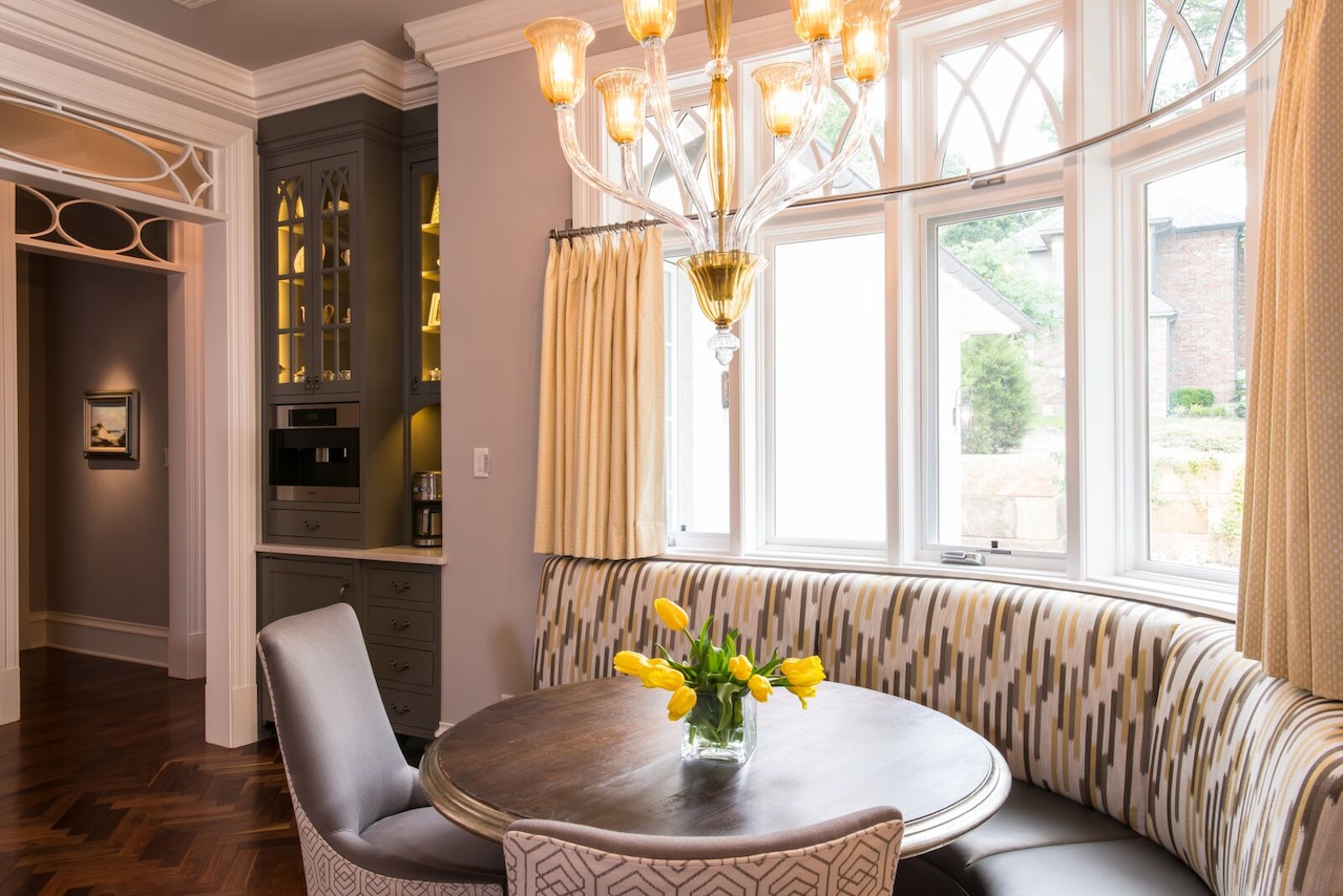 Mitchell Gold chairs with a lively fabric on the back add to the charm at the curvy seating area. A built-in Miele coffee machine is nearby.