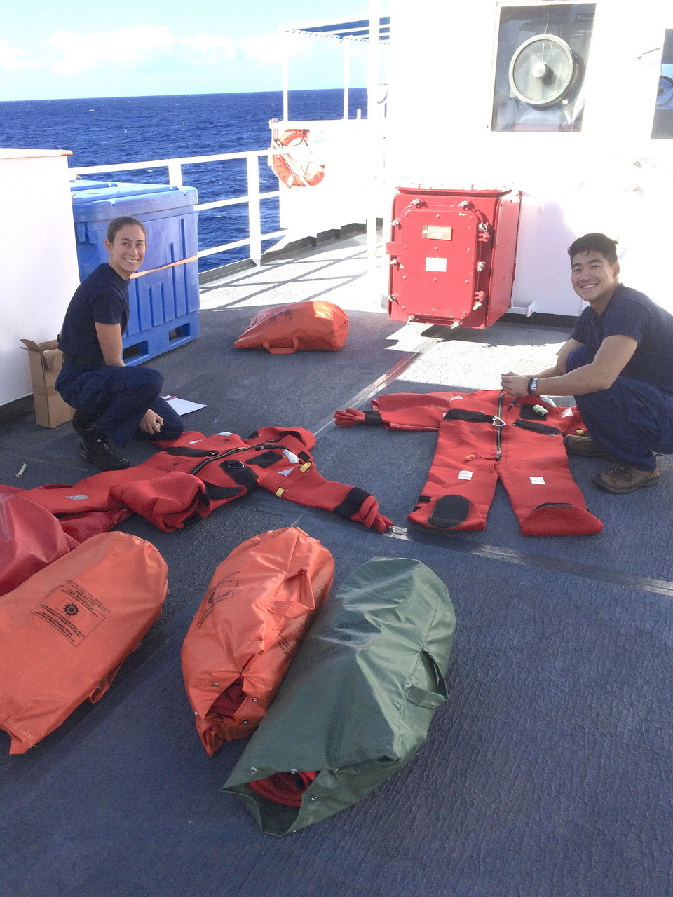 Ensigns Moore and Park check the condition of survival suits (a.k.a. "gumby suits") before a weekly abandon ship drill. Photo: NOAA Fisheries/Suzanne Yin.