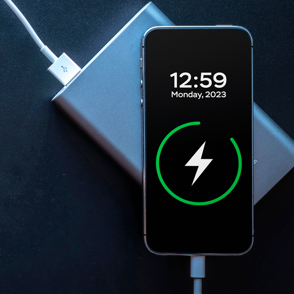 Two charging smartphones, with the one on top having its touchscreen facing the camera