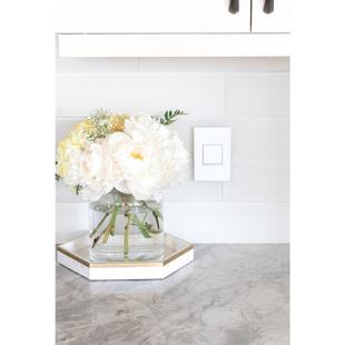 adorne Collection mirror white wall plate next to bouquet of white flowers