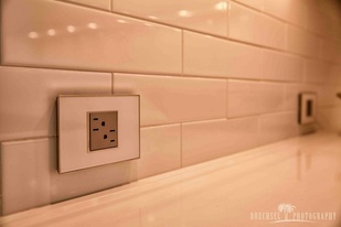 adorne collection mirror white wall plate with magnesium outlet installed on white subway tile