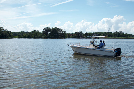 Two anglers sit at the wheel of a private boat on the Chesapeake Bay.