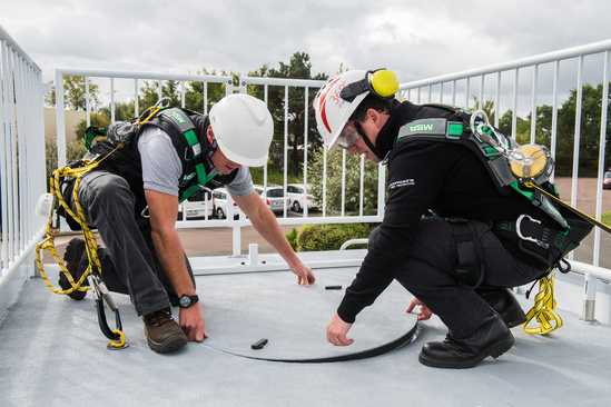 Two industrial workers open a confined space during a rescue training class